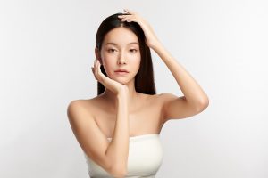 hermosa-joven-mujer-asiatica-con-piel-limpia-fresca-sobre-fondo-blanco-asimetría facial