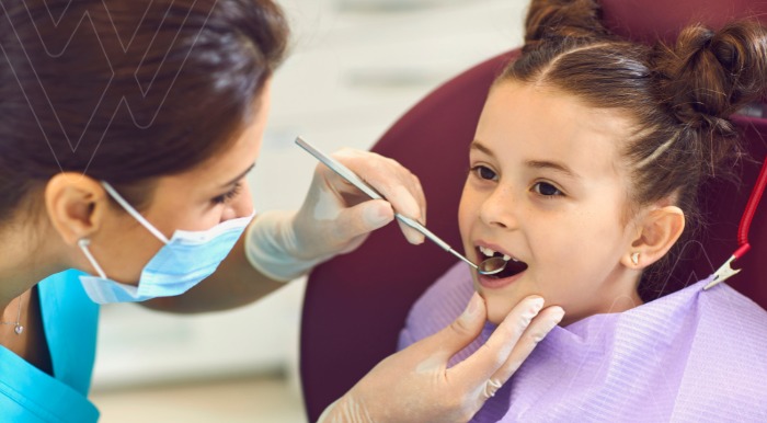 Foto niña siendo examinada por el dentista en la clínica denta. Contexto: gingivitis en niños infantil
